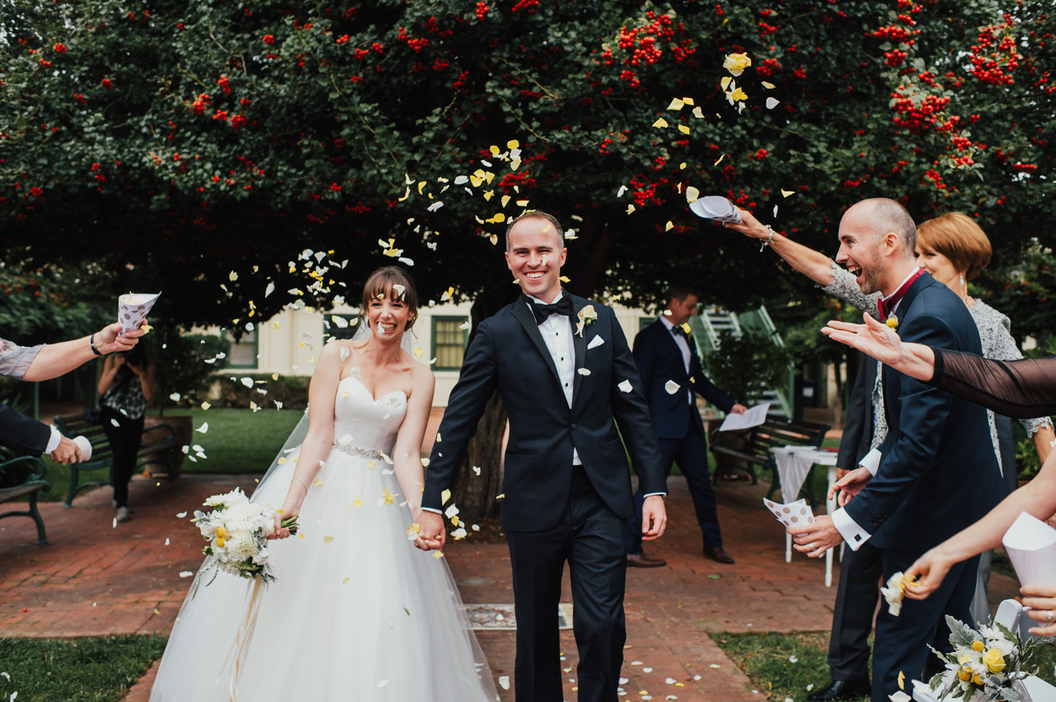 Intimate wedding ceremony with flower petals in a courtyard.