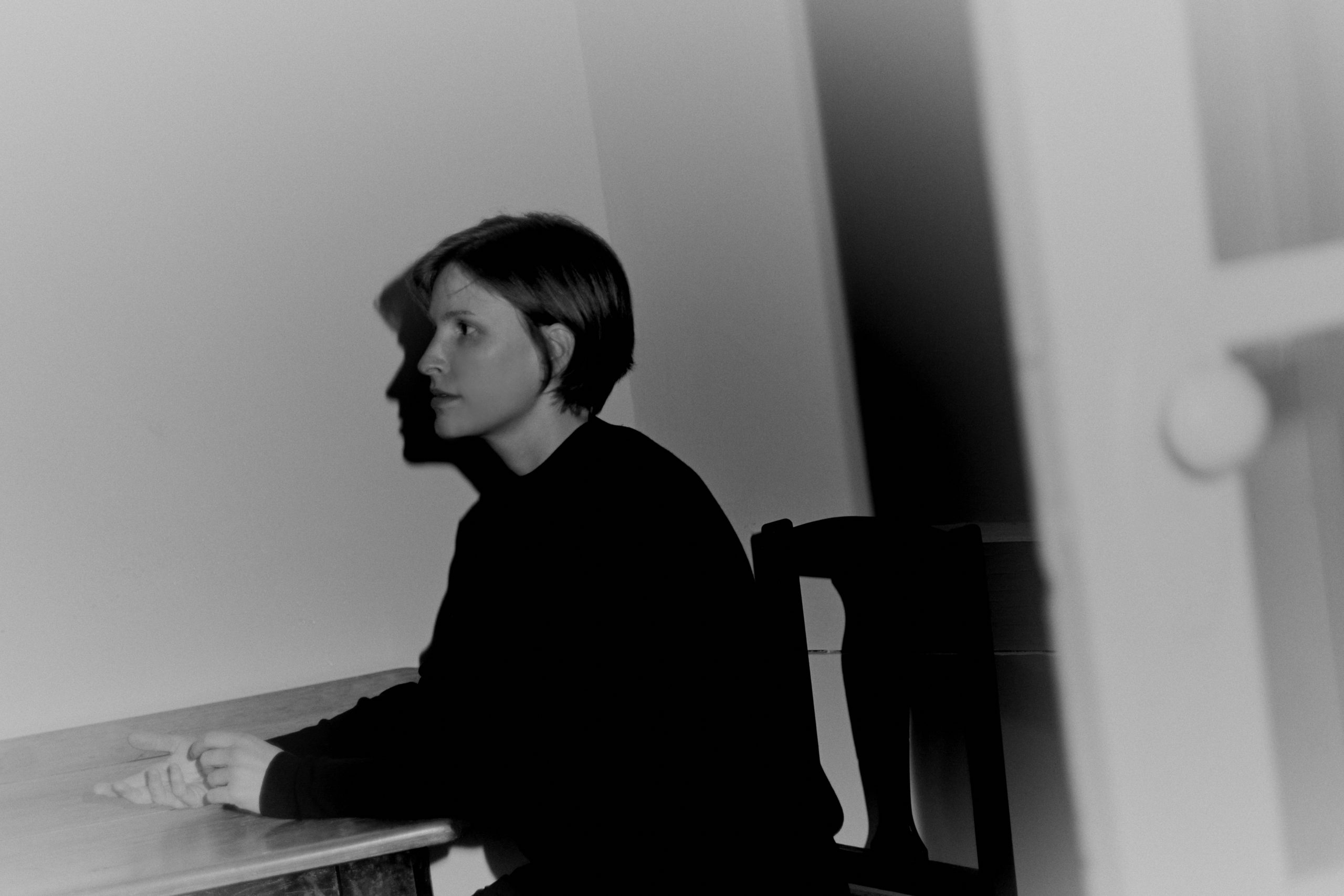 A woman sitting at a piano in profile. This is a black and white image