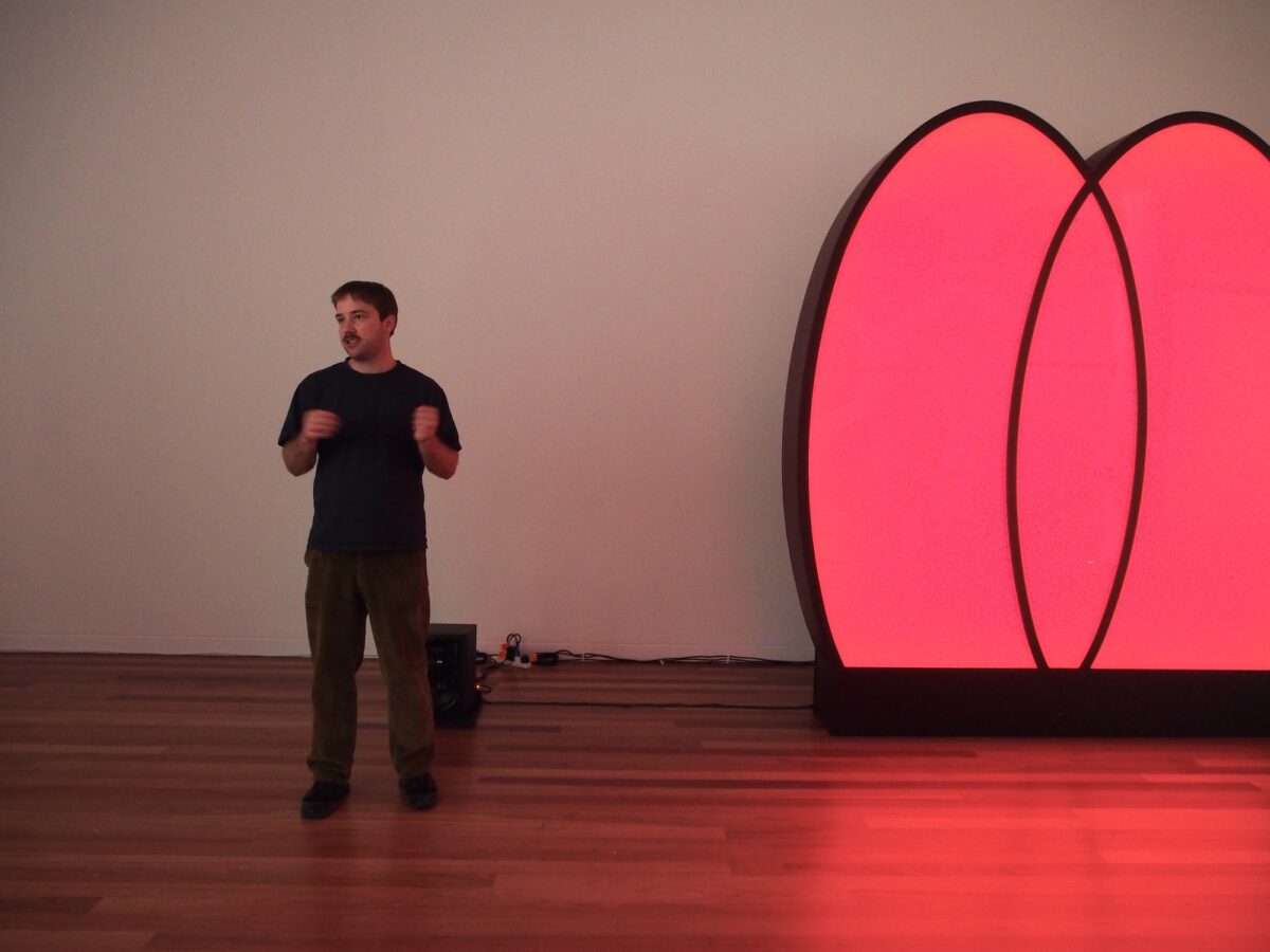 Tyler stands next to his glowing red light installation.