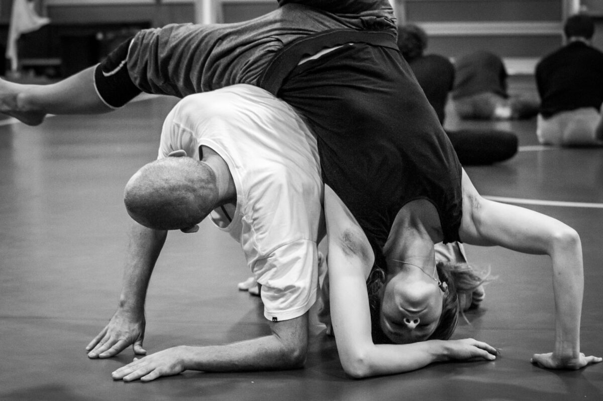 Two dancers topple over one another in a black and white image