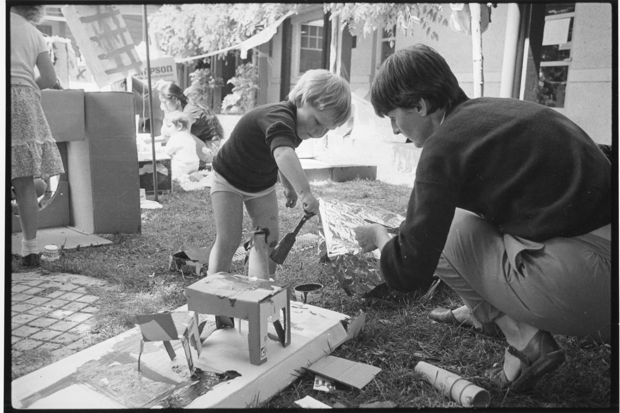 A young boy plays with paint and sculpture