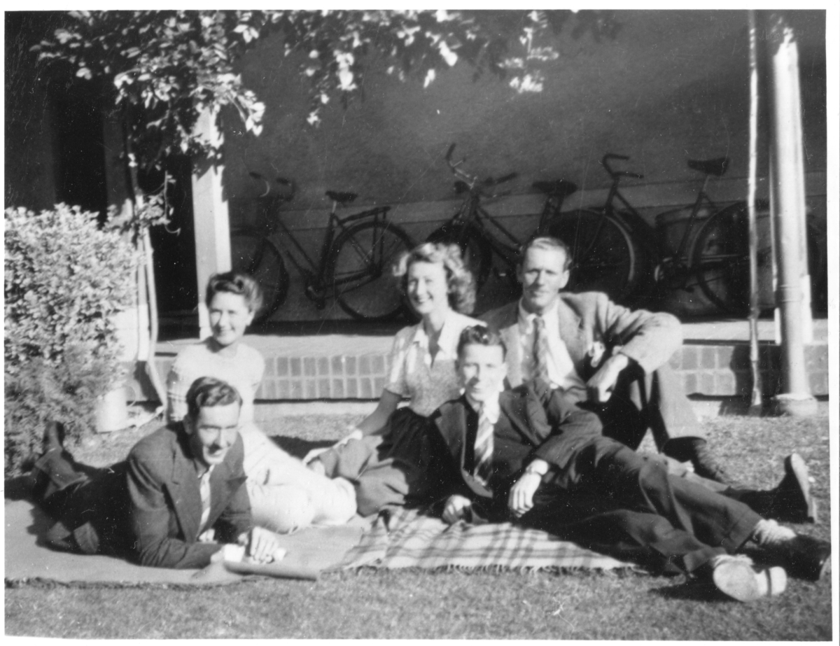 An old black and white photograph of men and women lounging on the lawns of Gorman House