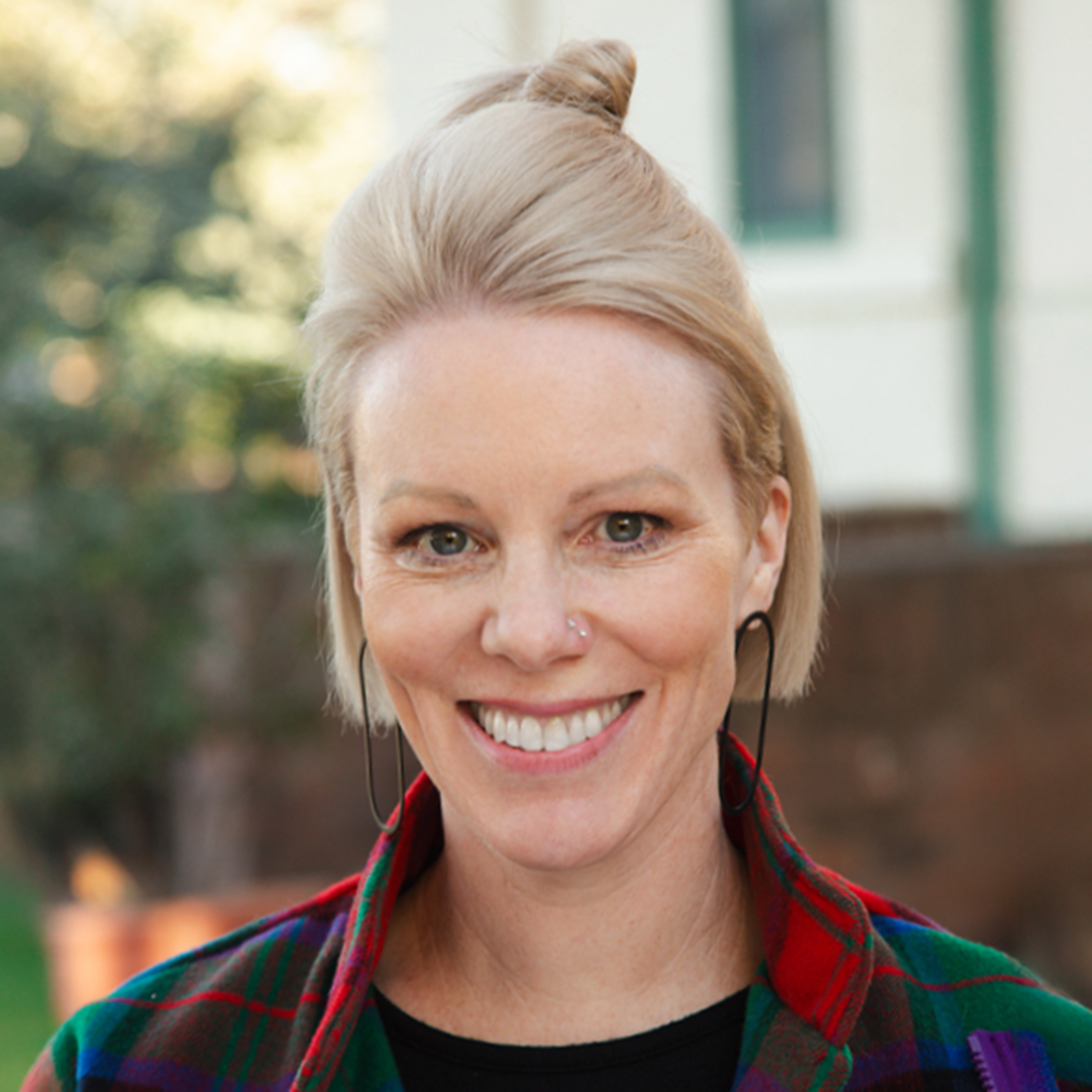 Portrait of Nancy Bennison wearing a tartan jacket.