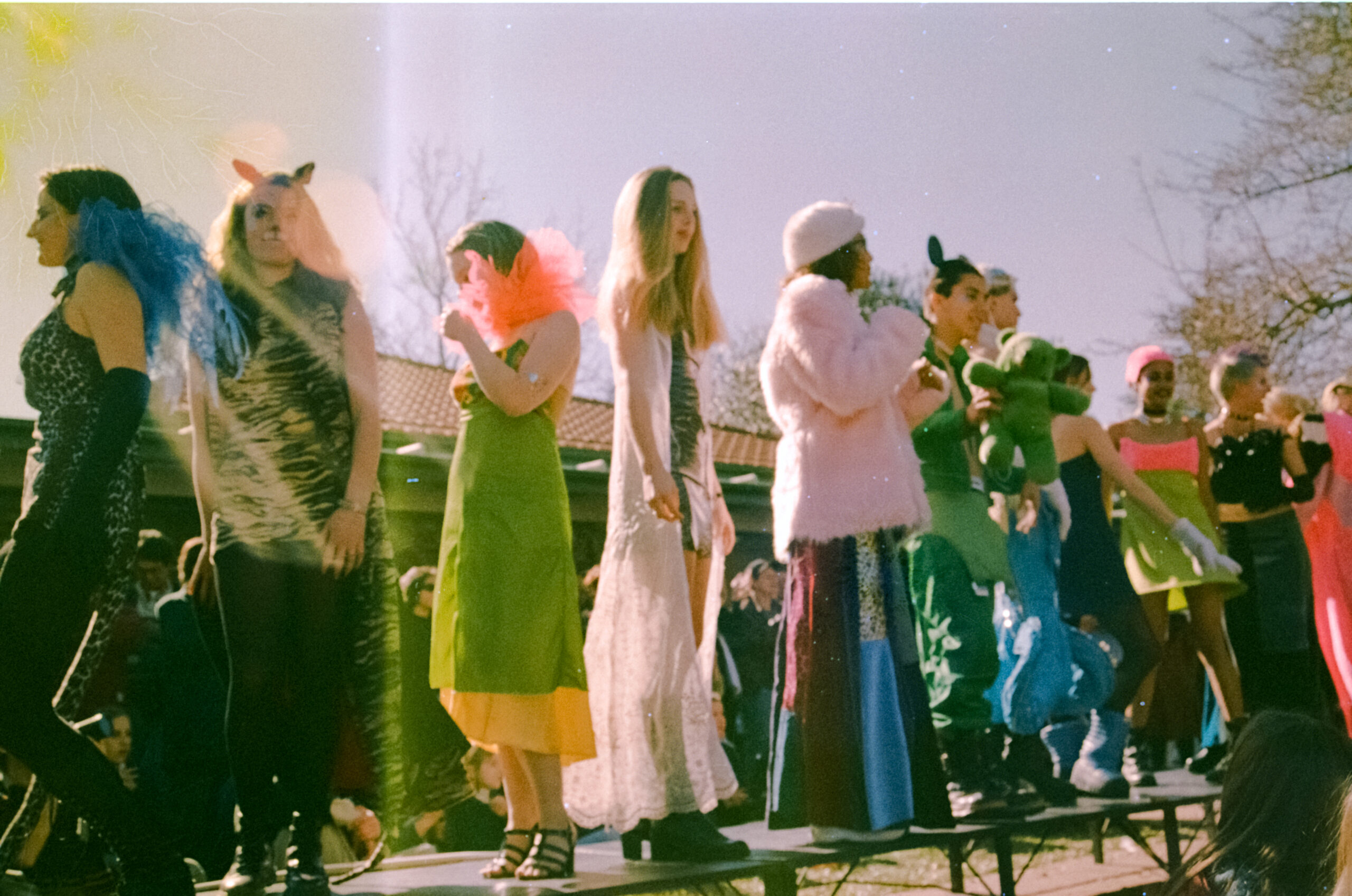 A faded film photograph of fashion show performers in